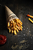 French fries in a paper bag with salt and ketchup