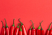 Red hot chilli peppers on minimal red background