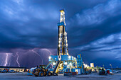 Oil well drilling rig operating near approaching lightning