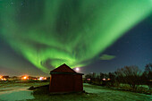 Northern lights display over a cabin