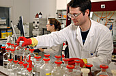 Laboratory assistant collecting bottle of ethanol