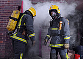Fire fighters prepare to douse a burning building