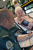 Paramedic taking notes from patient