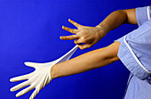 Young student nurse putting on latex gloves