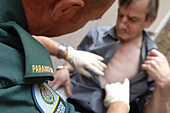 Paramedic stabilising an elderly man