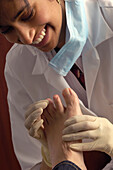 Podiatrist examining the foot of a young patient