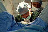 Surgeons operating on a patient's rectum