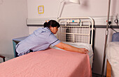 Staff nurse making a bed