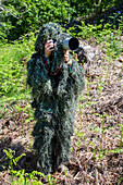 Wildlife photographer wearing a camouflage suit