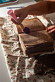 Restorer working on a deteriorated old book, Armenia
