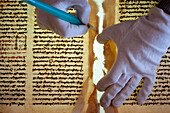 Restorer cleaning and consolidating a manuscript with glue