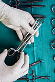 Gloved hands holding surgical instruments