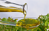 Frisches Olivenöl über Salat geben