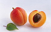 Whole and half apricots with leaf