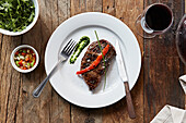 Grilled beef steak garnished with pepper, chives and fresh sea salt