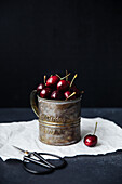 Fresh cherries in vintage tin mug