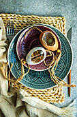 Festliche Tischdekoration mit Keramiktellern und Eierschalen als Osternest