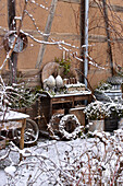 Arrangement on and around table in snowy garden