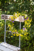 Floral wreath of wildflowers on a rustic garden chair