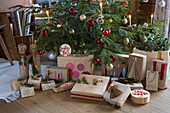 Christmas tree with presents and red baubles in a living room