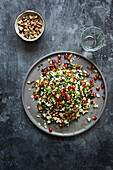 Middle eastern salad with pomegranate, pistachio, rice, almonds, parsley and caramelised onions