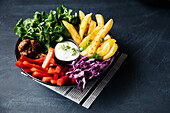 Bunte Veggie Bowl mit Kartoffelspalten und veganen 'Hackbällchen'