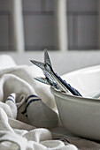 Fresh needle fish, sardines on the kitchen table, linen tablecloth