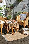 Wicker armchair, table and rug on terrace; accessories with DIY decoration