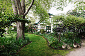 Half-timbered house in the garden with lawn and flower beds