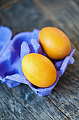 Zwei gelbe Ostereier in einem lila Eierkarton