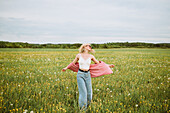 Junge blonde Frau auf einer sommerlichen Blumenwiese