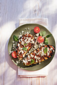 Grilled aubergine halves with pesto rosso and feta cheese