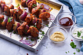 Spicy seitan and onion skewers with three different dips, vegan