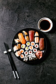 Sushi rolls set with fresh salmon, tuna, eel and prawns on rice. Flat lay, copy space