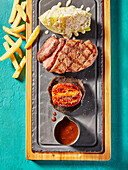 Steak platter with white cabbage, grilled tomato, sauce and chips