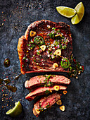 Partially sliced steak with chimichurri