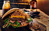 A cheeseburger with bacon, crsipy fried onions and rocket salad