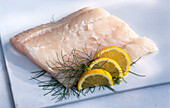 Cod fillet with lemons and dill on a light background