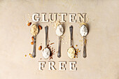 'Gluten free' aus Holzbuchstaben und Metalllöffel mit verschiedenen glutenfreien Mehlsorten