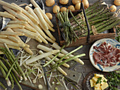 Still life with green and white asparagus, potatoes, parma ham, and butter