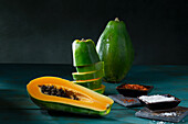 Papaya, ganz und halbiert, Scheibenturm mit Chiliflocken und Kokosraspeln