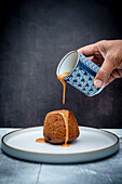 Steamed pudding with sauce being poured