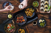 Verschiedene japanische Gerichte auf dunklem Holztisch