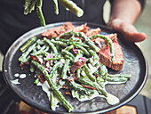 Green bean salad with bacon and a slice of rump roast