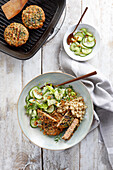 Salmon burgers served with a scythe and cucumber salad