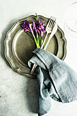 Spring floral table setting decorated with wild purple iris flowers on concrete table