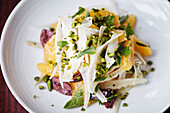 A orange and fennel salad with black olives and pistachios