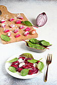 Beet gnocchi with onions and baby spinach