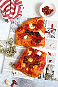 Pizza with mozzarella, tomatoes and olives on newspaper