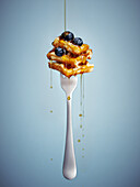 Maple syrup drizzled on skewered waffles with blueberries